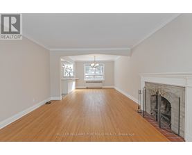 A spacious room with a fireplace and wooden floors.