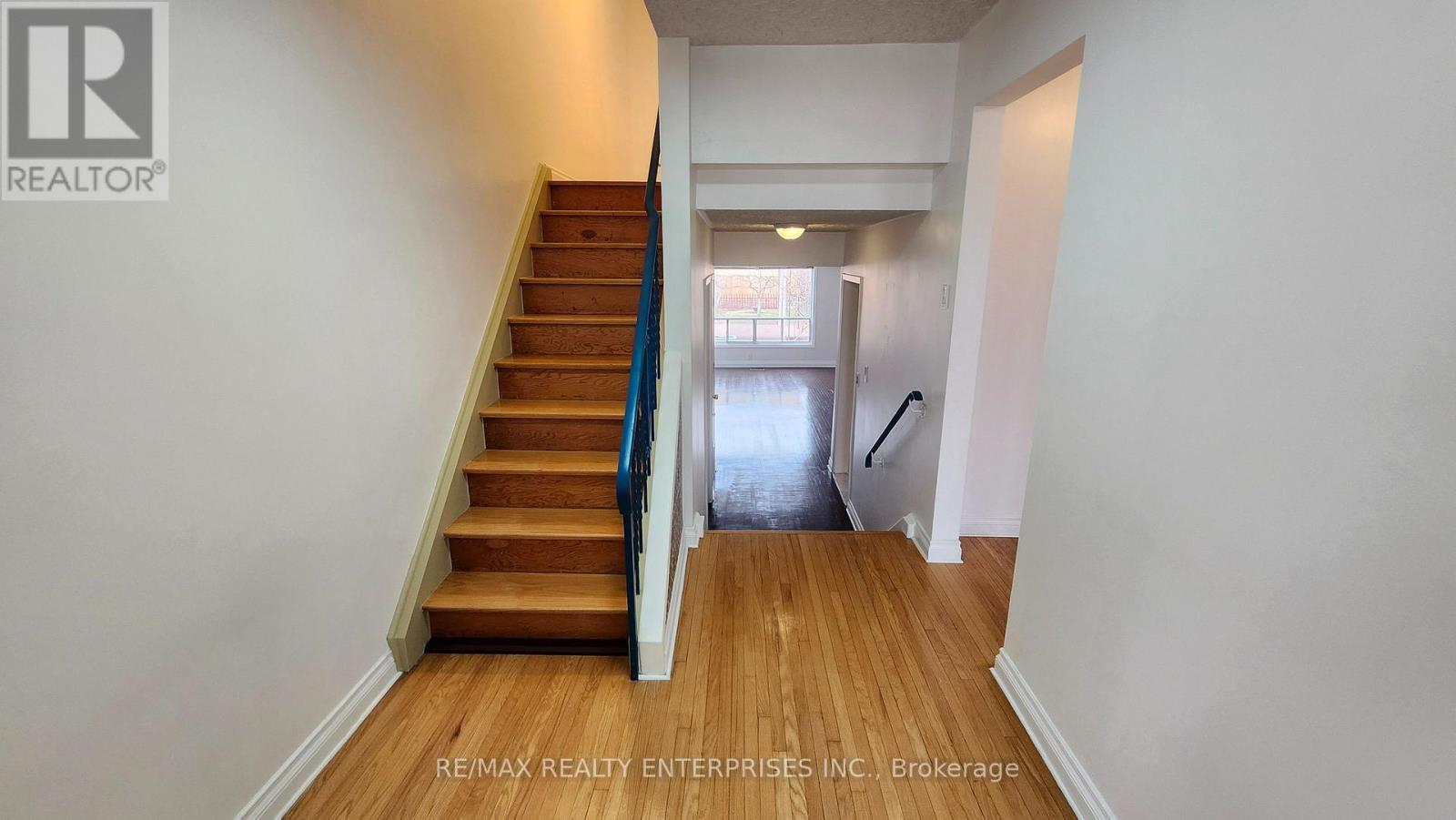 A hallway with a staircase leading to a second floor.
