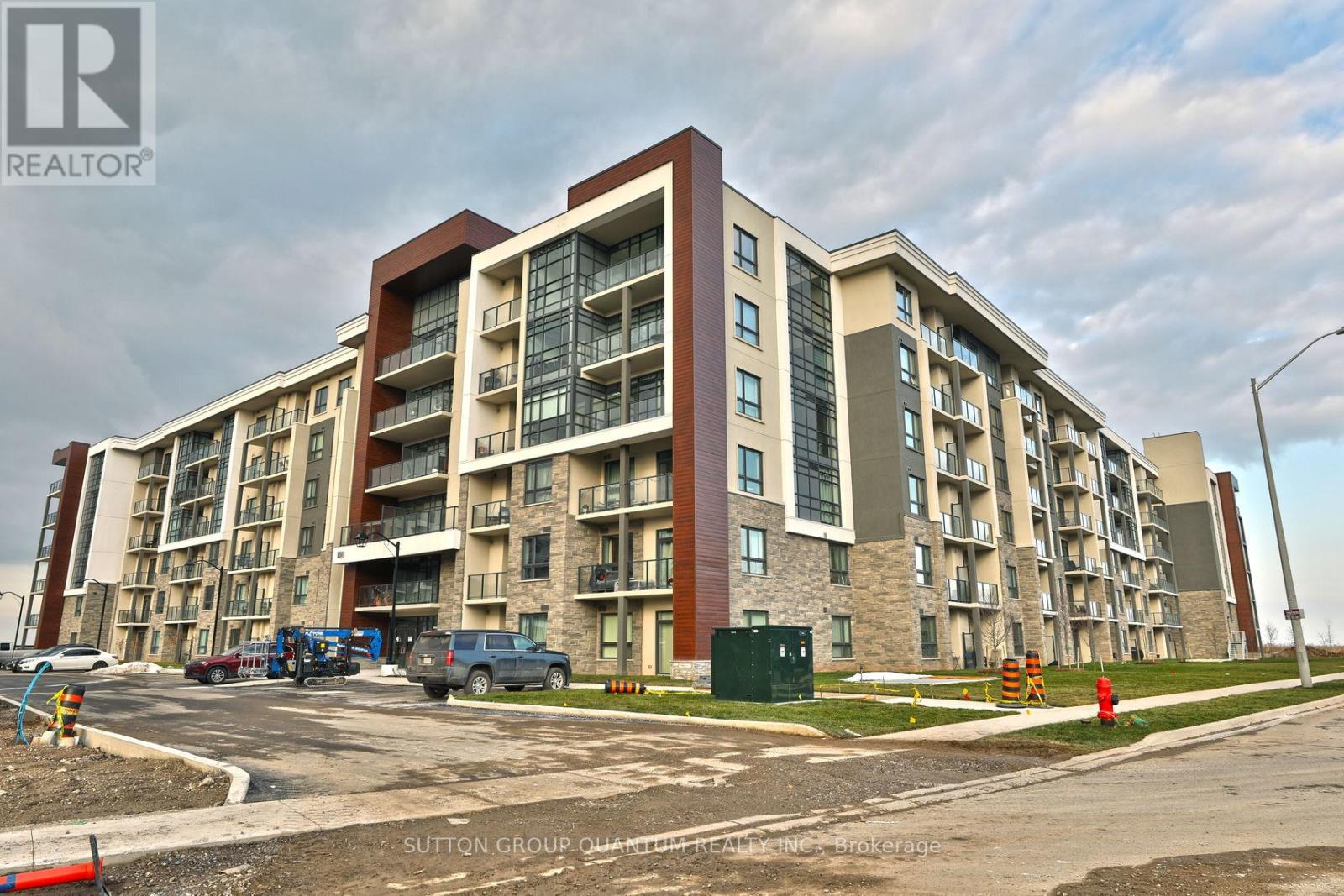A large apartment building with a parking lot in front.
