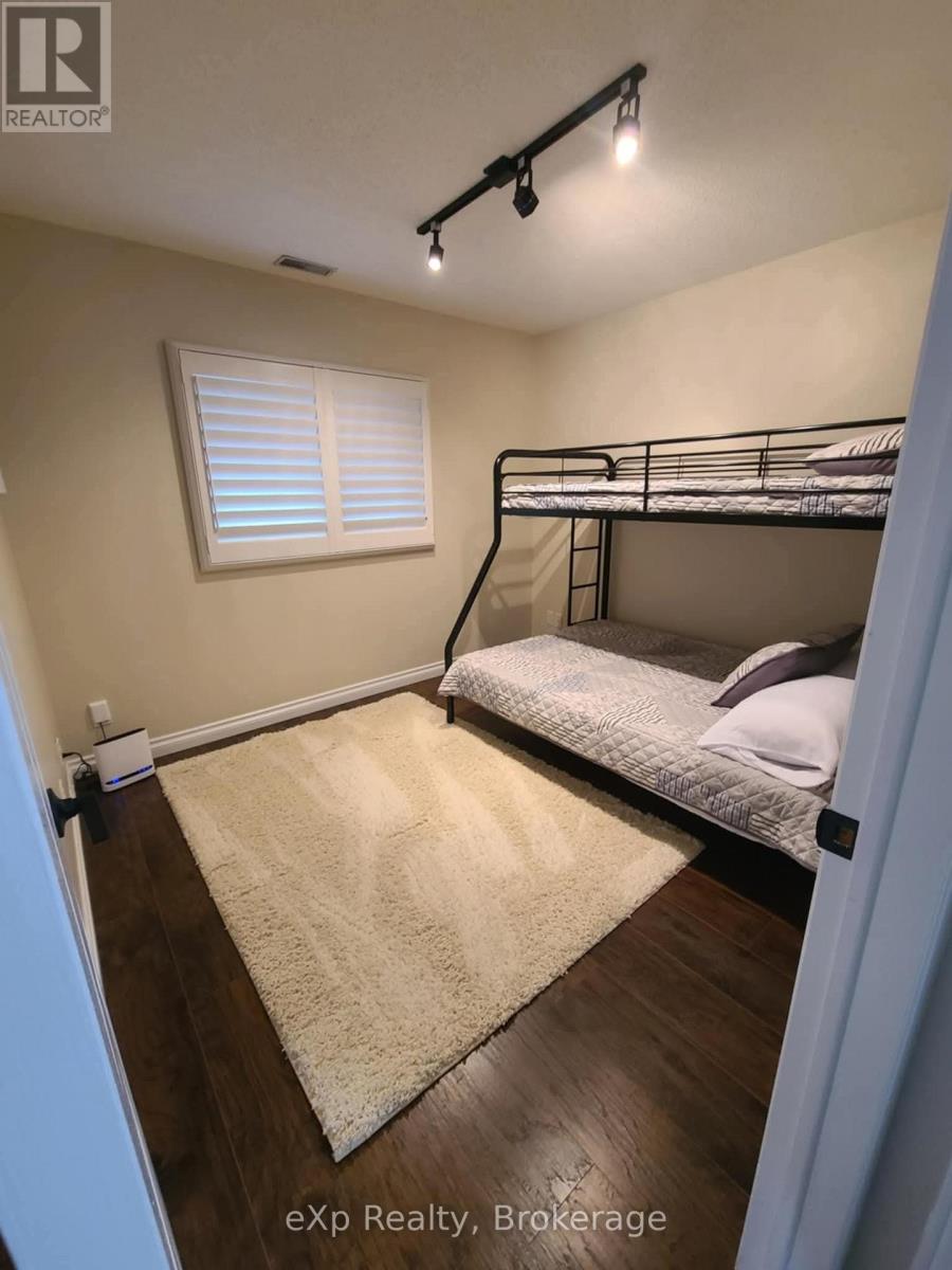 A bedroom with a bunk bed and a rug on the floor.