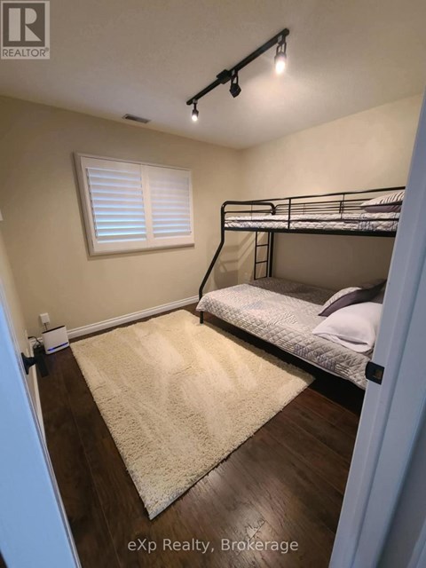 A bedroom with a bunk bed and a rug on the floor.