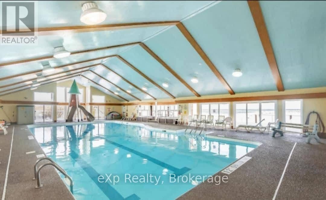 A large indoor swimming pool with a slide in a spacious room.