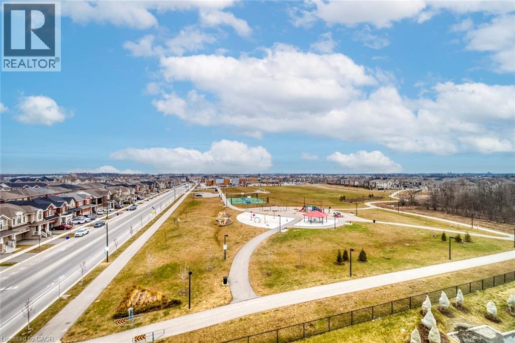 A park with a playground and a road with cars.