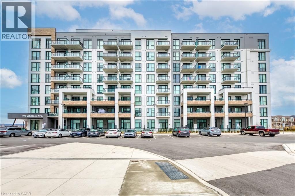 A large apartment building with a parking lot in front.