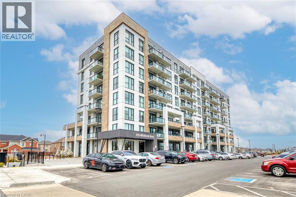 A large apartment building with cars parked in front.