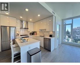 A modern kitchen with a dining table and a view of the city.