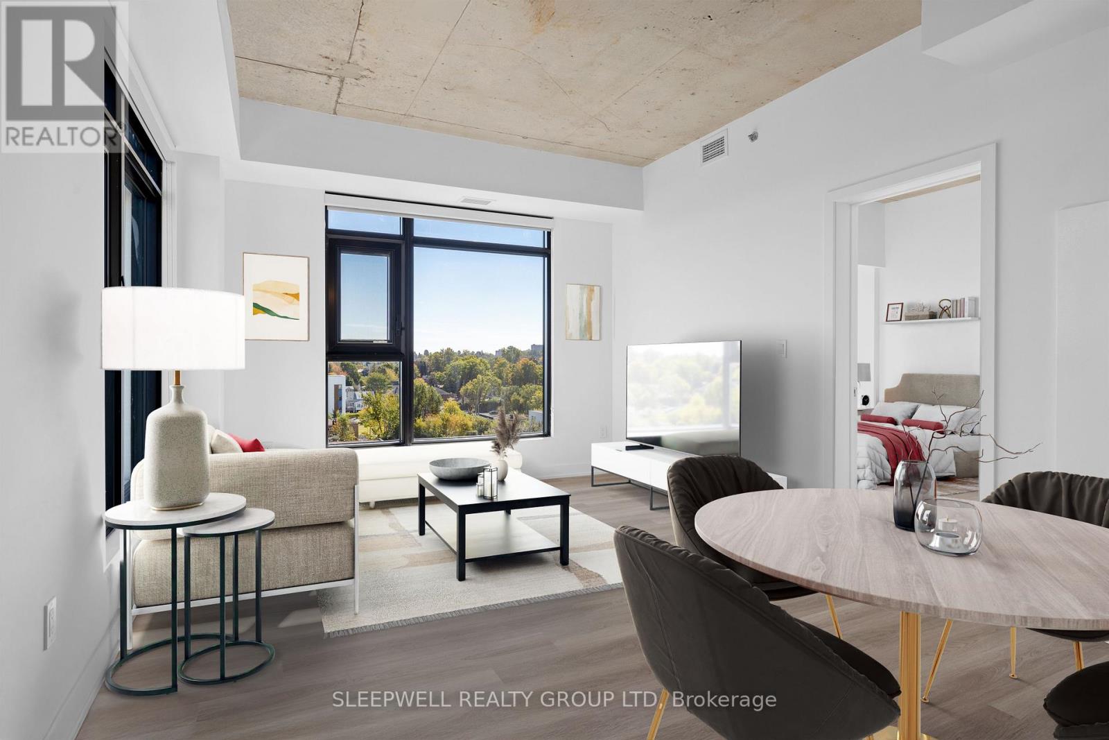 A modern living room with a large window and a view of trees outside.