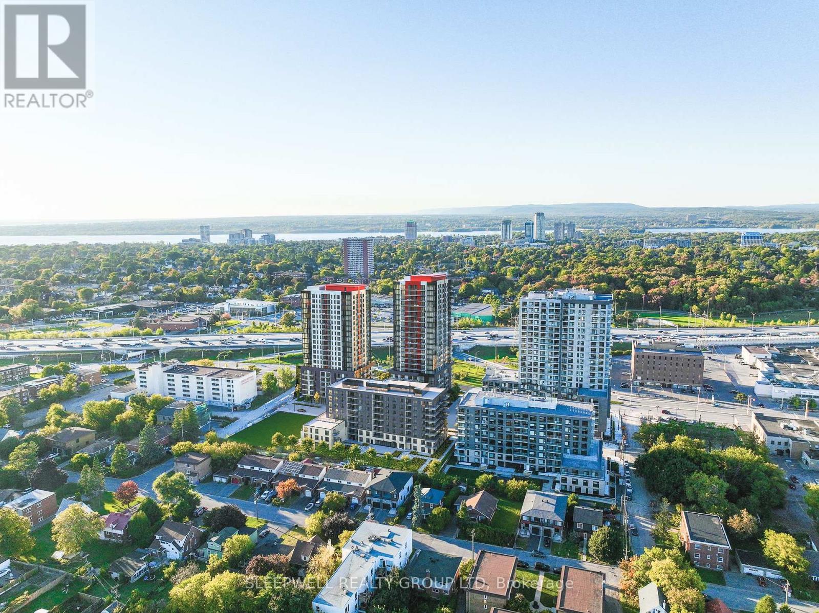A bird's eye view of a city with apartment buildings and a bridge in the distance.