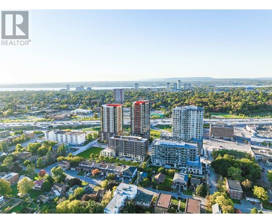 A bird's eye view of a city with apartment buildings and a bridge in the distance.