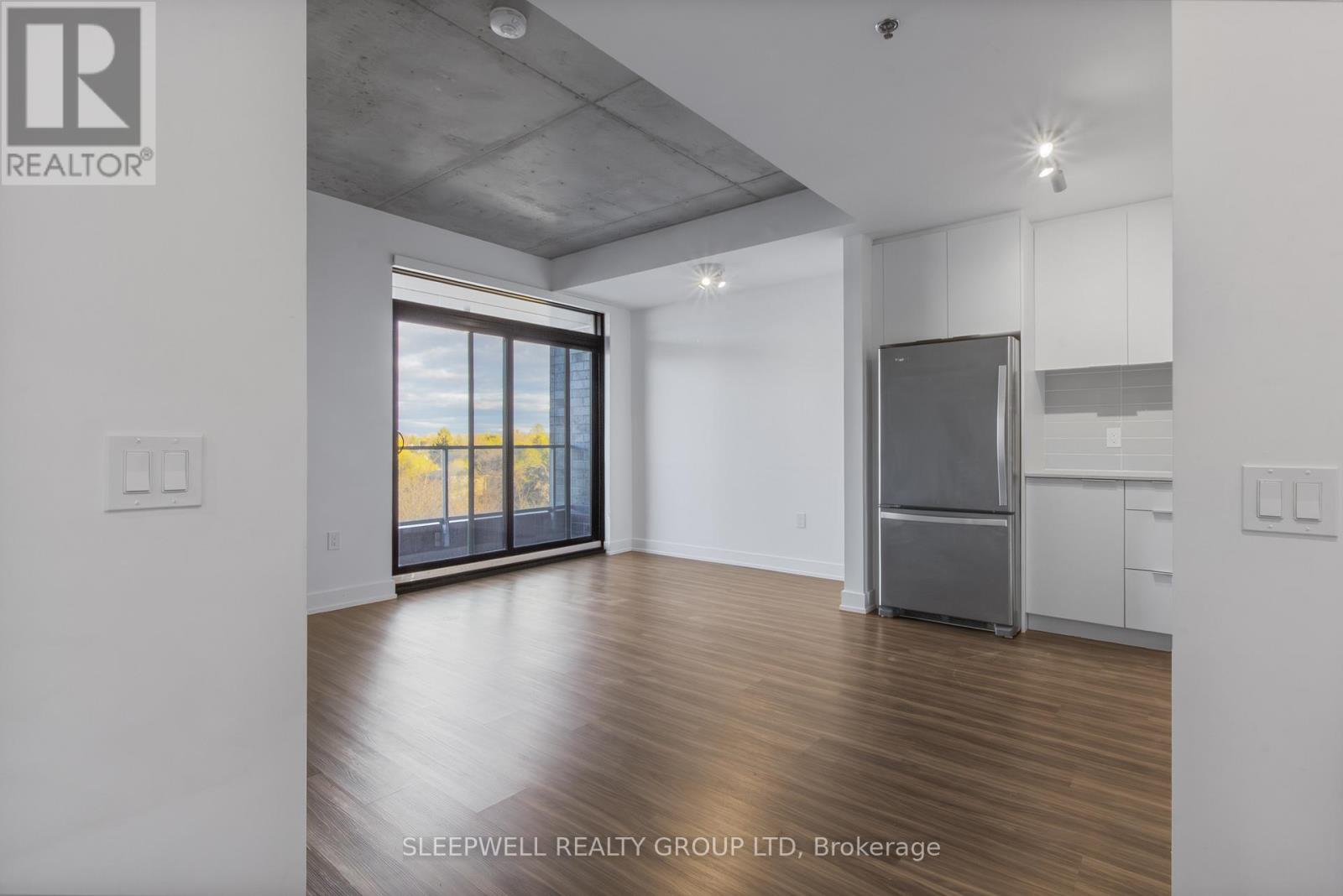 A room with a refrigerator and a window overlooking the beach.