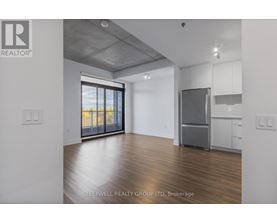 A room with a refrigerator and a window overlooking the beach.