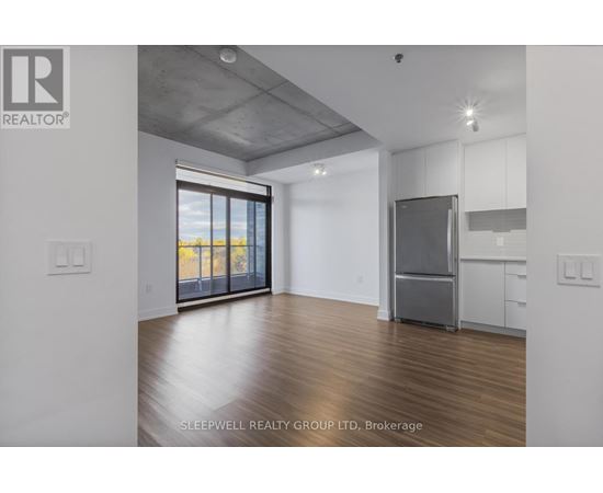 A room with a refrigerator and a window overlooking the beach.