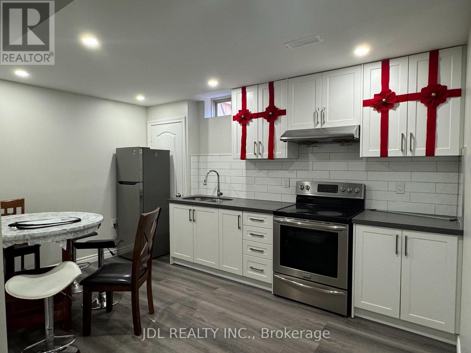 A kitchen with white cabinets and a black stove top oven.