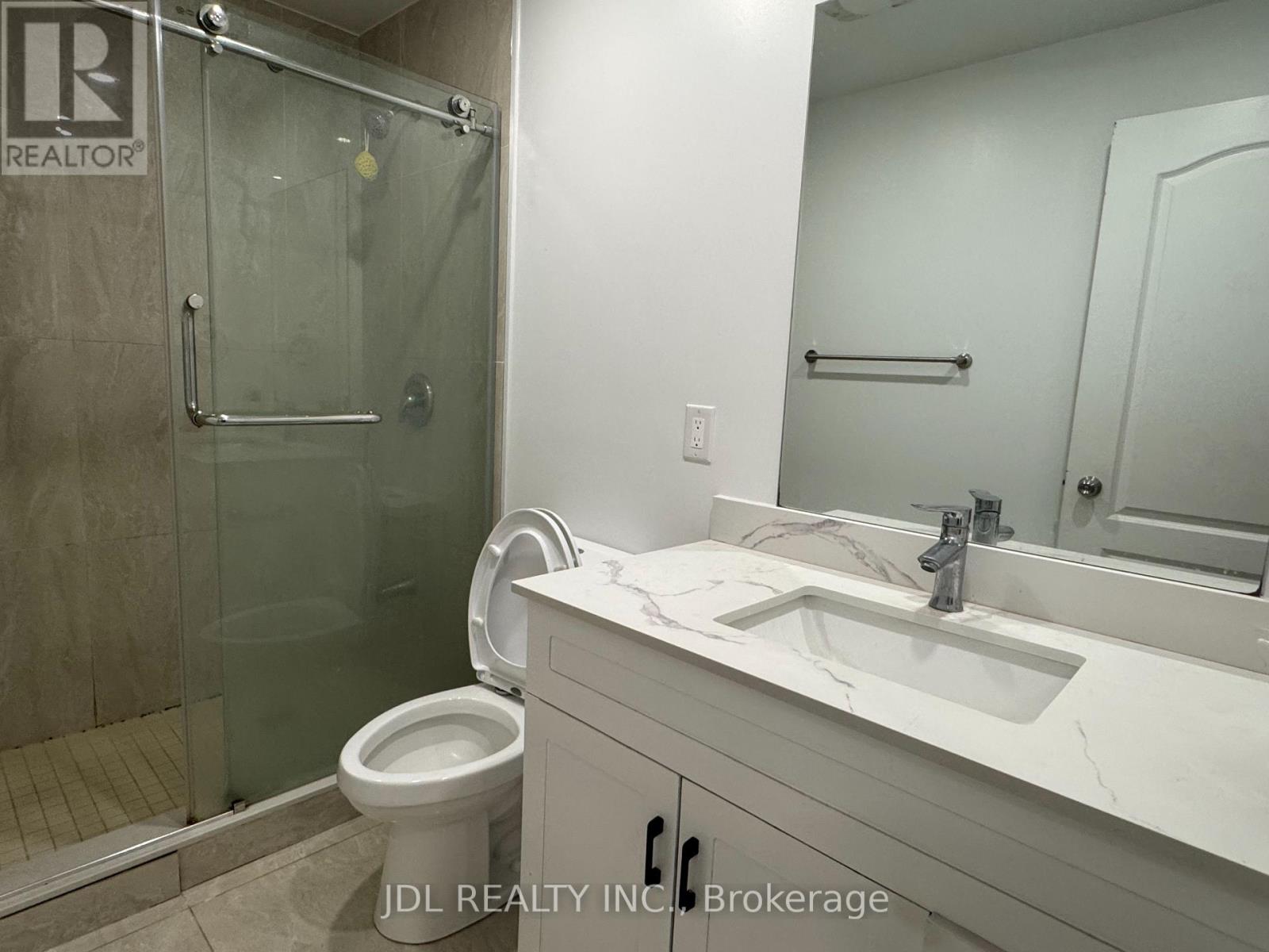 A bathroom with a toilet, sink, and shower.