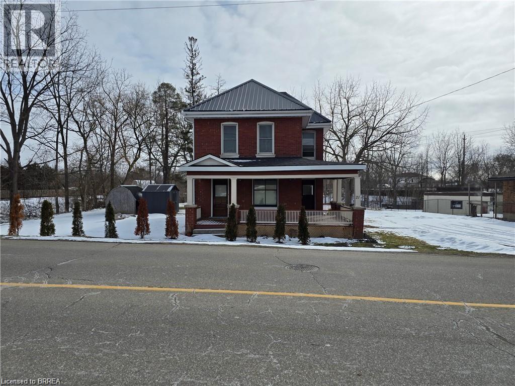 A red brick house with a black roof and a white door.