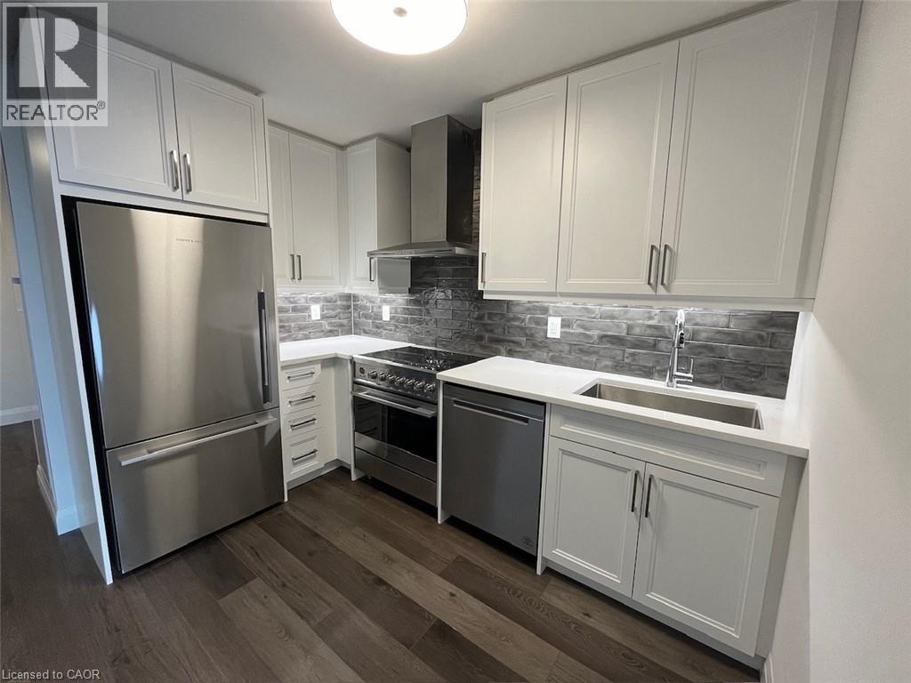 A kitchen with white cabinets and a stainless steel refrigerator.