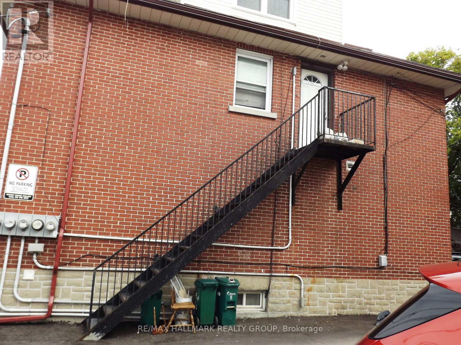 A red brick building with a black metal staircase.