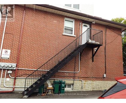 A red brick building with a black metal staircase.