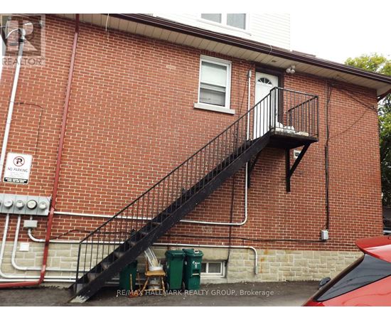A red brick building with a black metal staircase.
