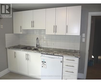 A kitchen with white cabinets and a white fridge.