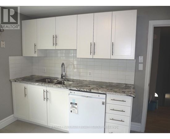 A kitchen with white cabinets and a white fridge.