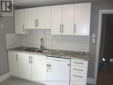 A kitchen with white cabinets and a white fridge.