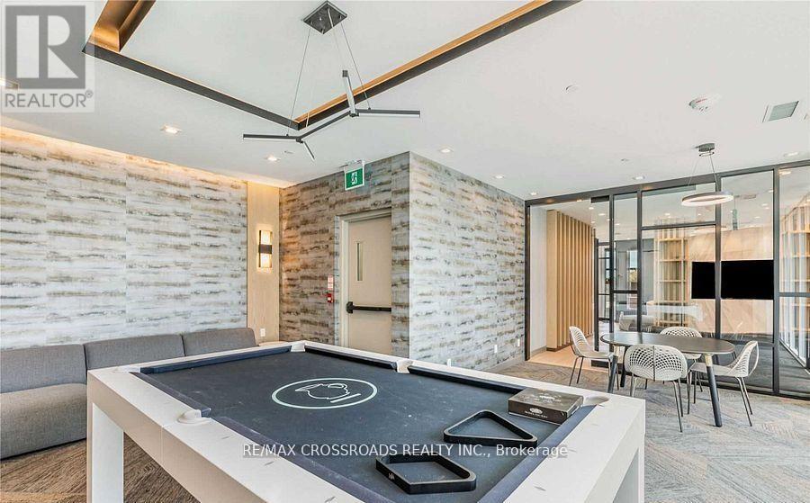 A modern living room with a pool table and a stone wall.