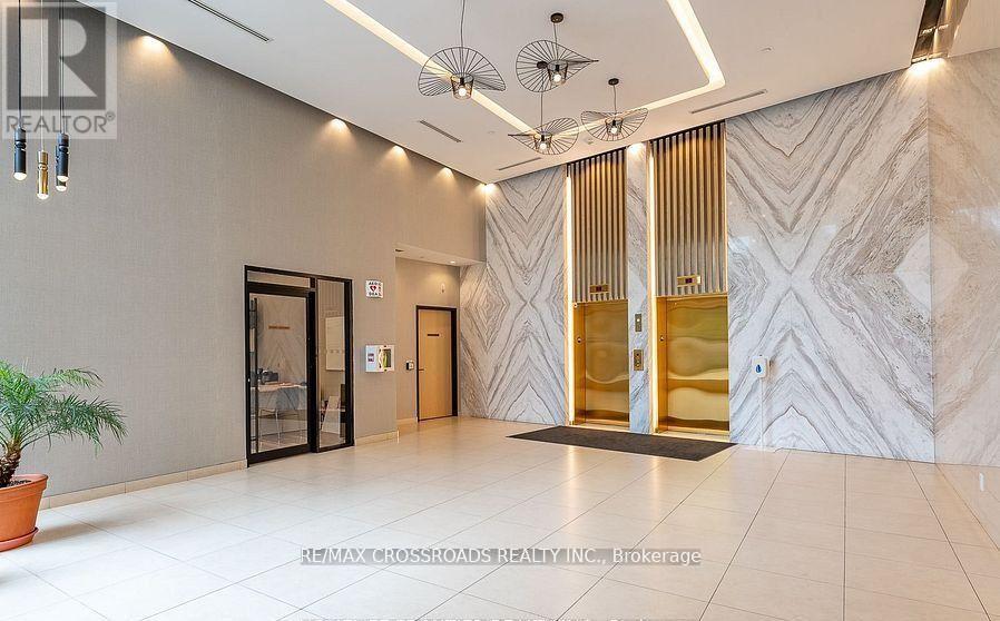 A spacious hallway with marble floors and a patterned wallpaper.