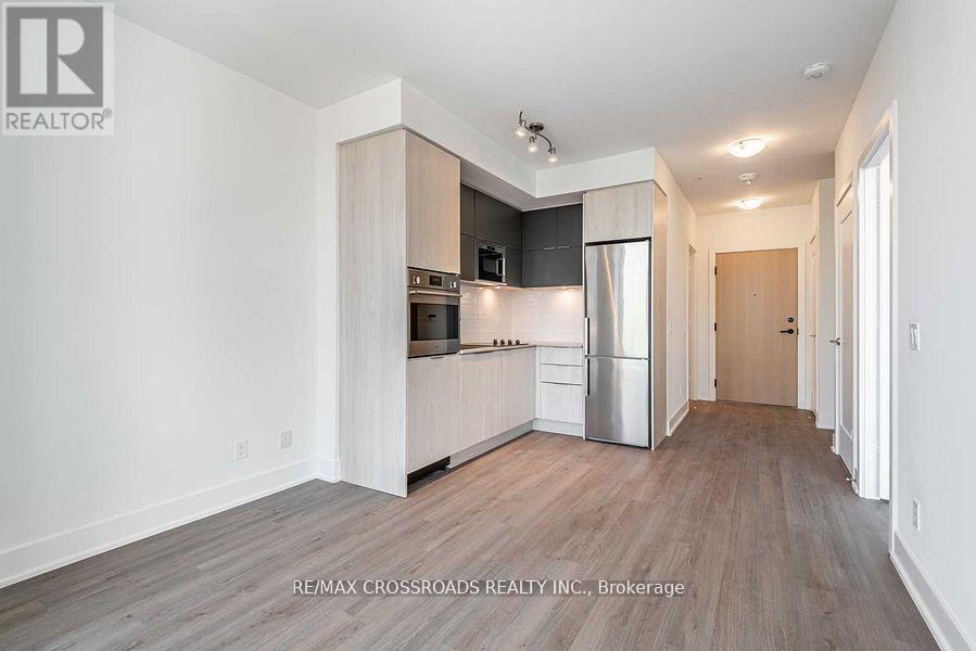 A spacious kitchen with white cabinets and a refrigerator.