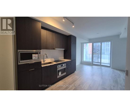 A kitchen with dark wood cabinets and a white countertop.