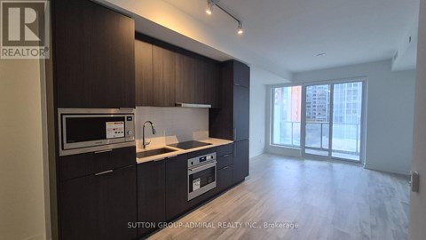 A kitchen with dark wood cabinets and a white countertop.