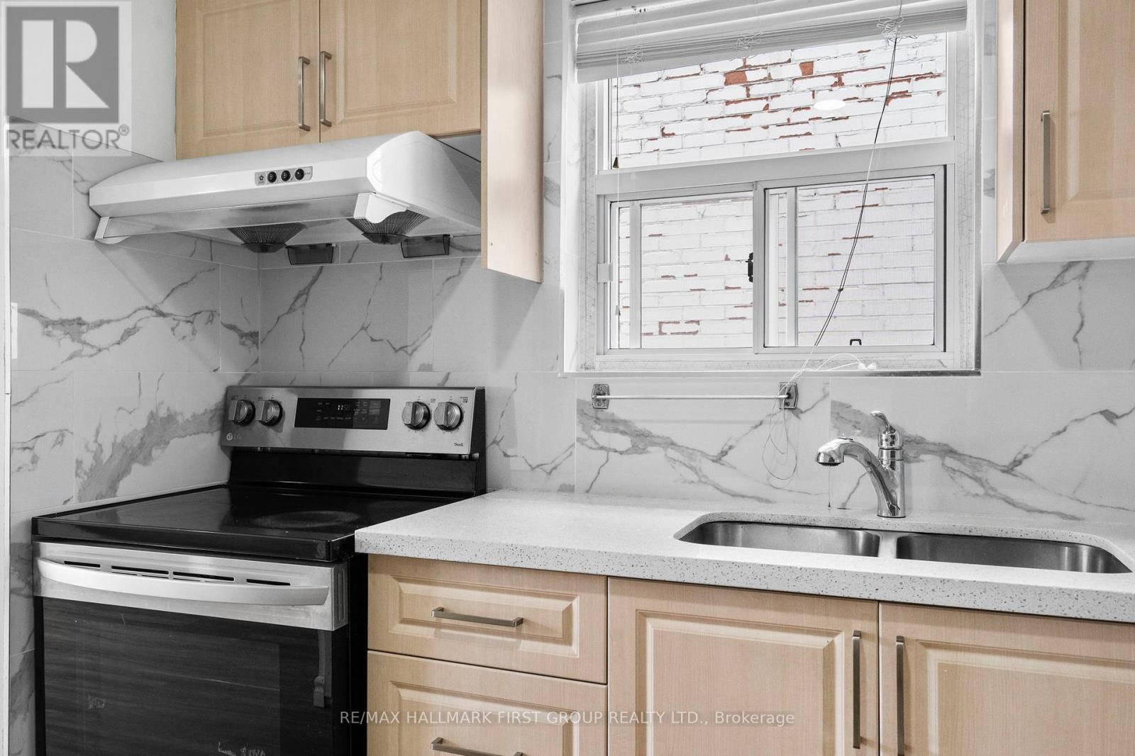 A kitchen with a black stove top oven and a white range hood.