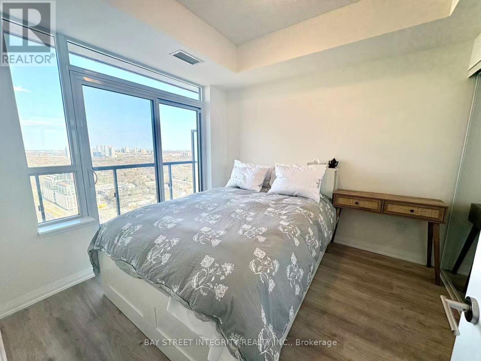 A bedroom with a large bed and a view of the outside.