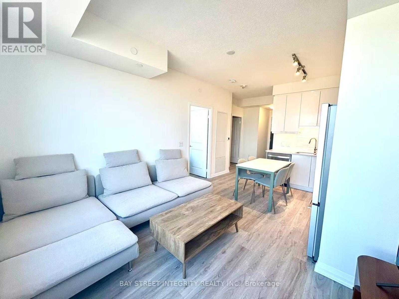 A living room with a grey couch and a wooden coffee table.