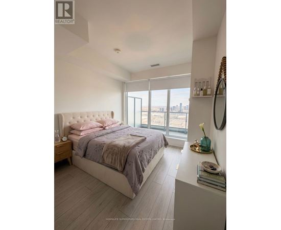 A bedroom with a large bed and a view of the city.
