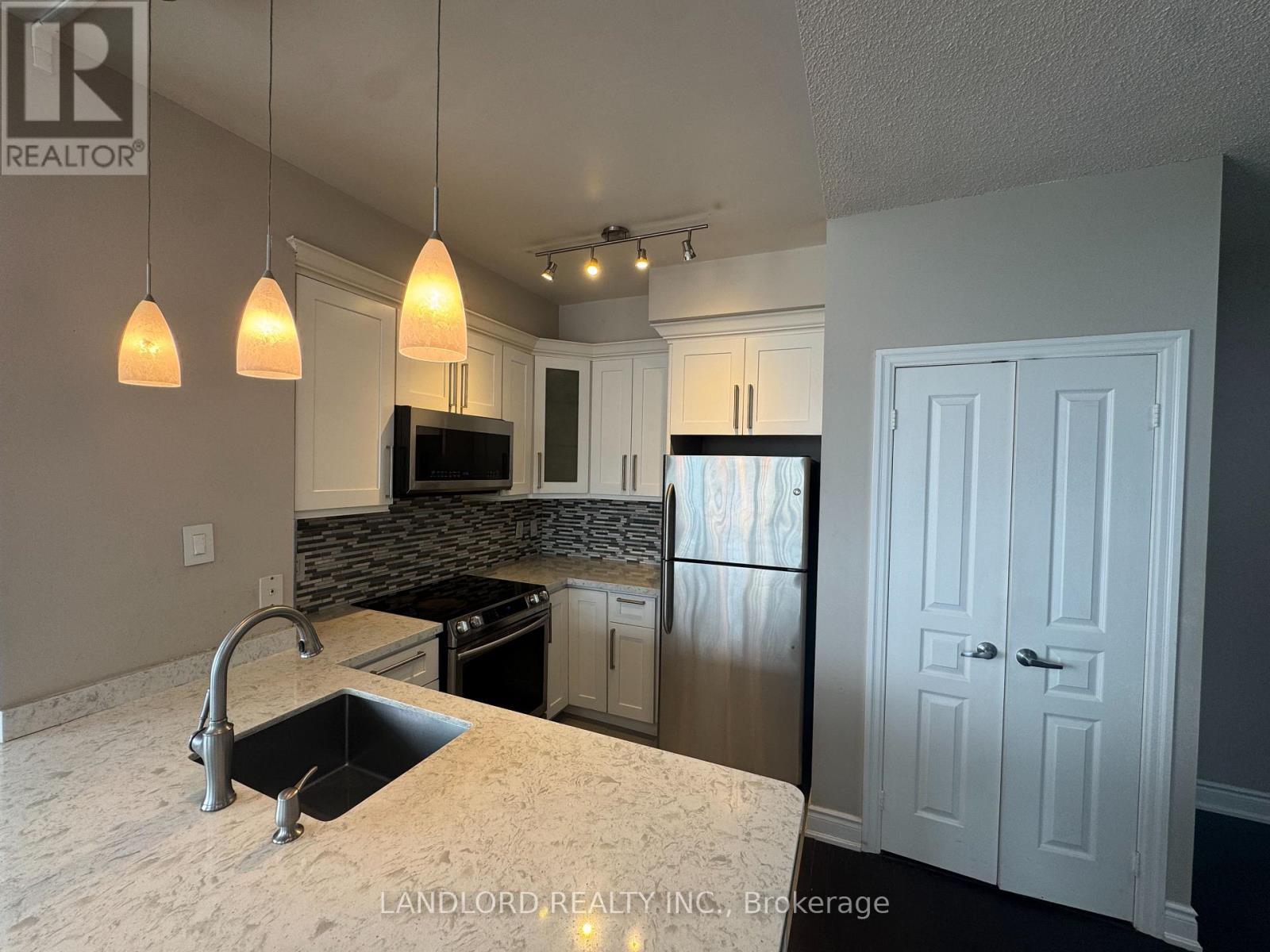 A kitchen with a sink, stove, and cabinets.