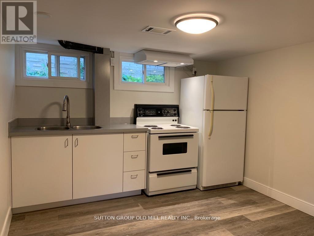 A kitchen with white cabinets and a white refrigerator.