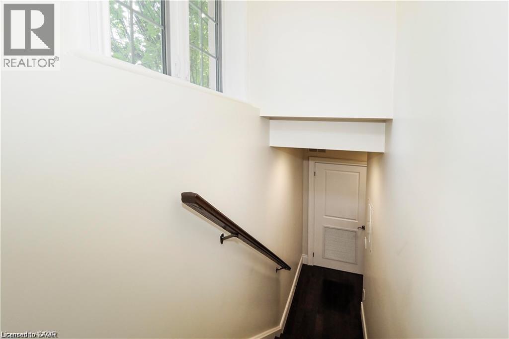 A stairway with a black handrail and a white door at the top.