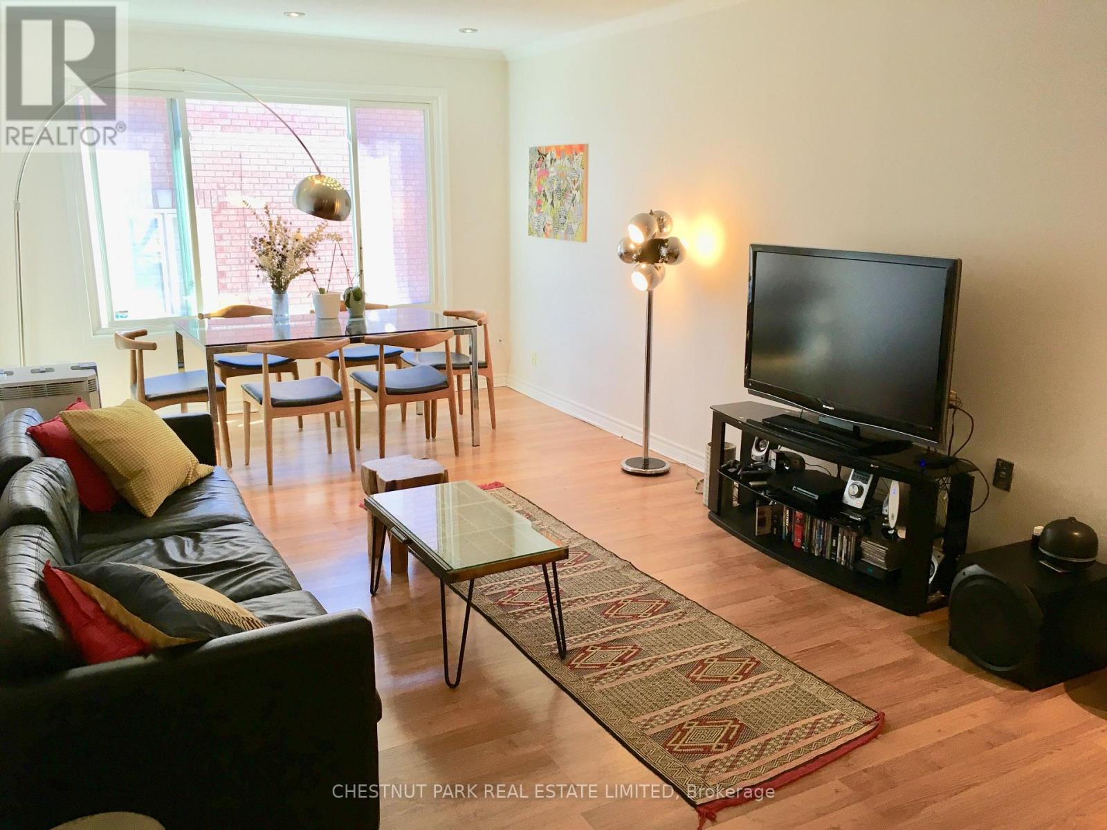 A living room with a black leather couch and a wooden coffee table.