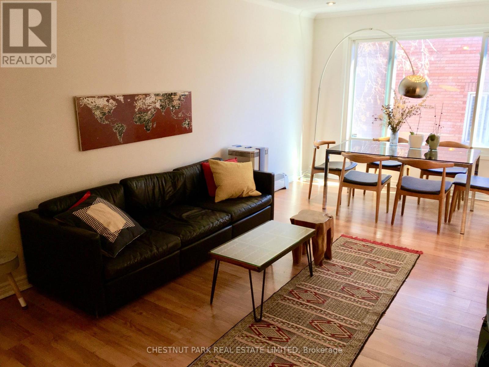 A living room with a black leather couch and a wooden coffee table.