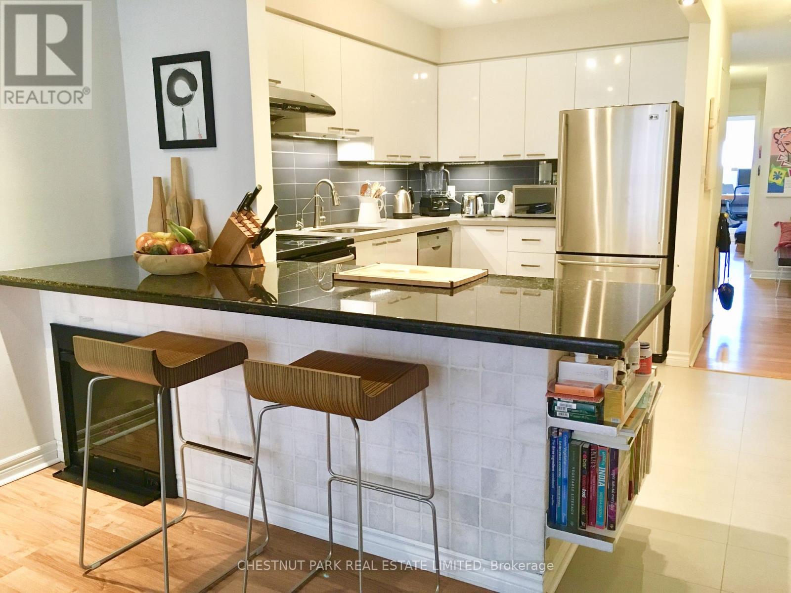A kitchen with a black counter top and white cabinets.