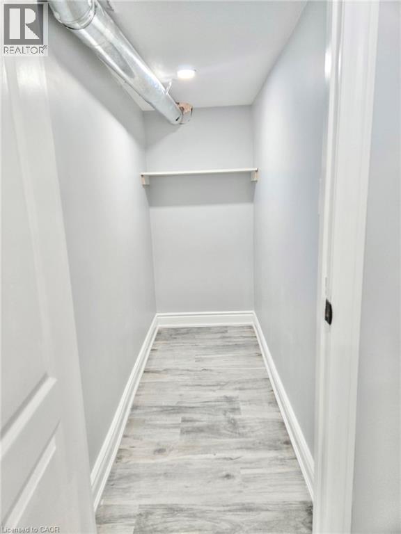 A long white hallway with wood flooring and white walls.