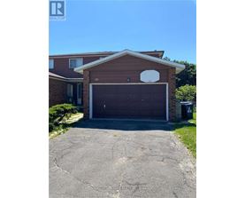 A house with a brown garage door and a white circular window above it.