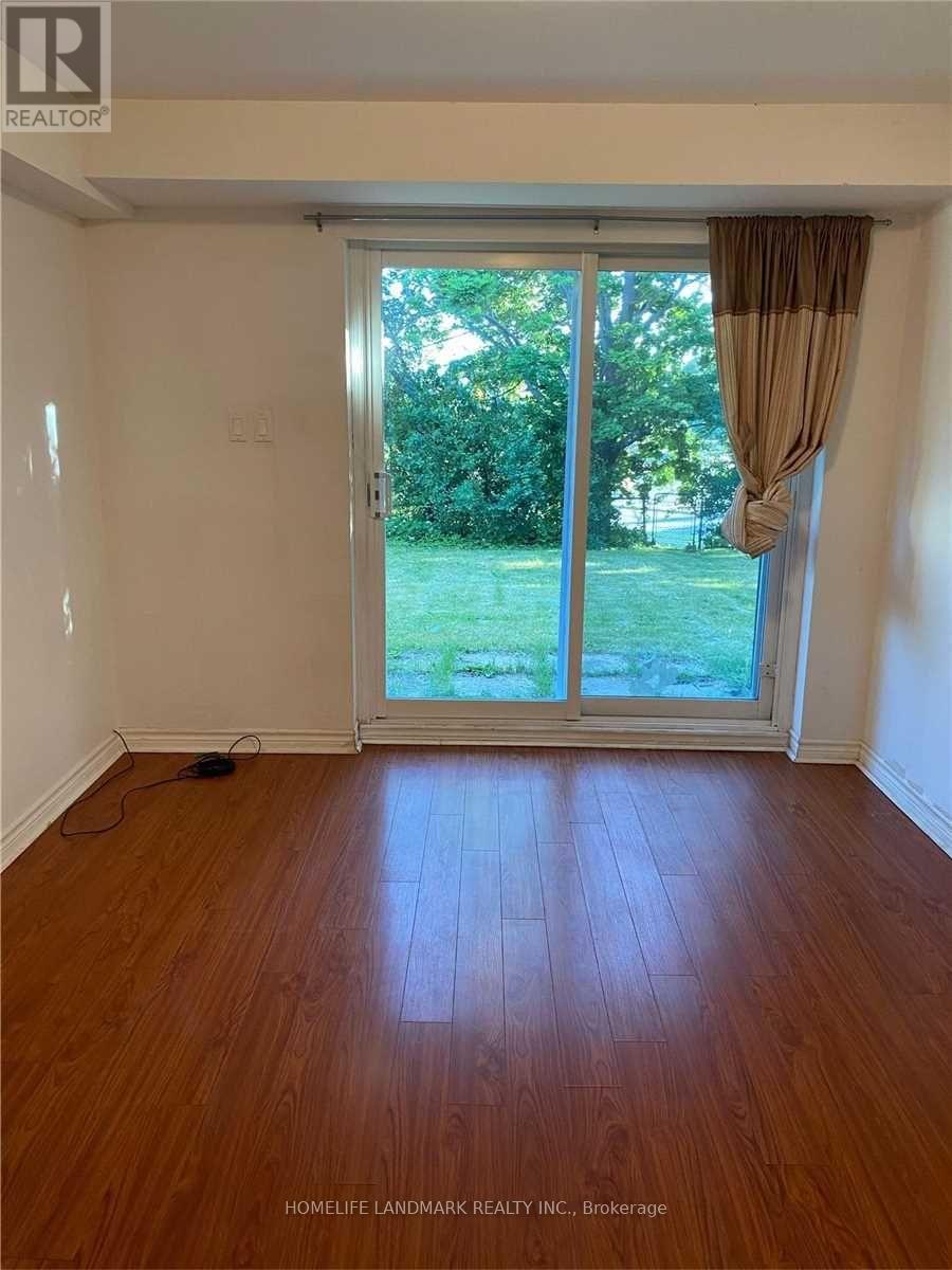 A room with a sliding glass door leading to a green lawn.