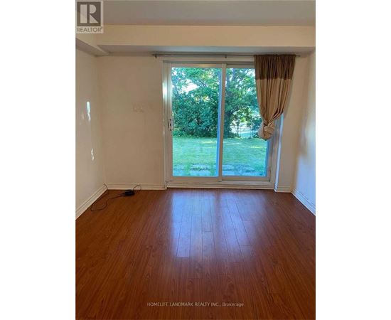 A room with a sliding glass door leading to a green lawn.