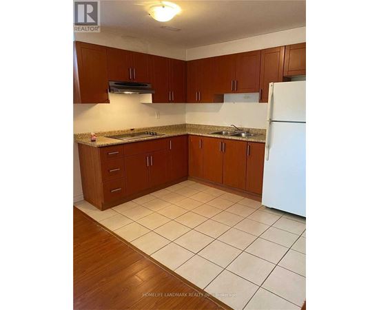 A kitchen with brown cabinets and a white refrigerator.