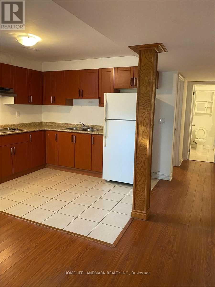 A kitchen with wooden cabinets and a white fridge.