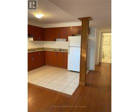 A kitchen with wooden cabinets and a white fridge.