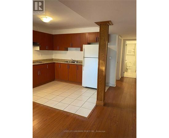A kitchen with wooden cabinets and a white fridge.