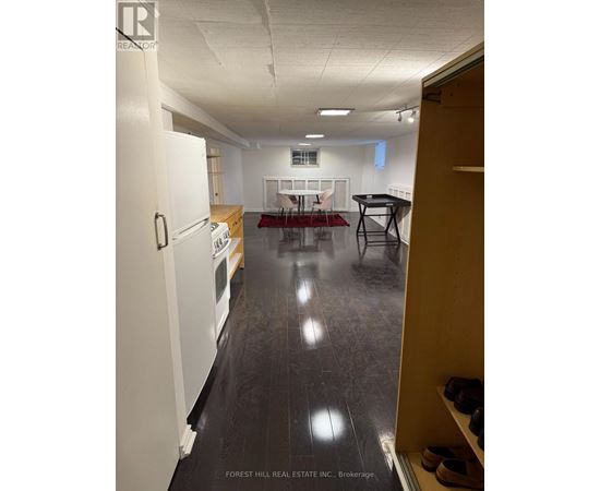 A kitchen with white appliances and a dining table with chairs.